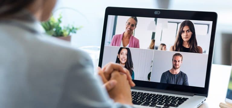 Female employee speaking on video call with diverse colleagues o